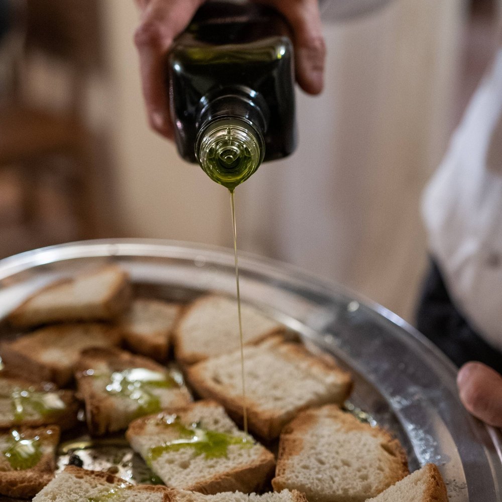 Scoprite la nostra azienda agricola in Umbria Olio versato sulle fette di pane su un vassoio