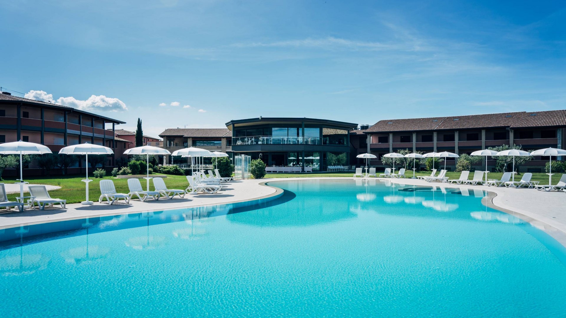 Un hotel a Santa Maria degli Angeli, Assisi? No, molto di più Piscina all'aperto con lettini e ombrelloni in un resort moderno